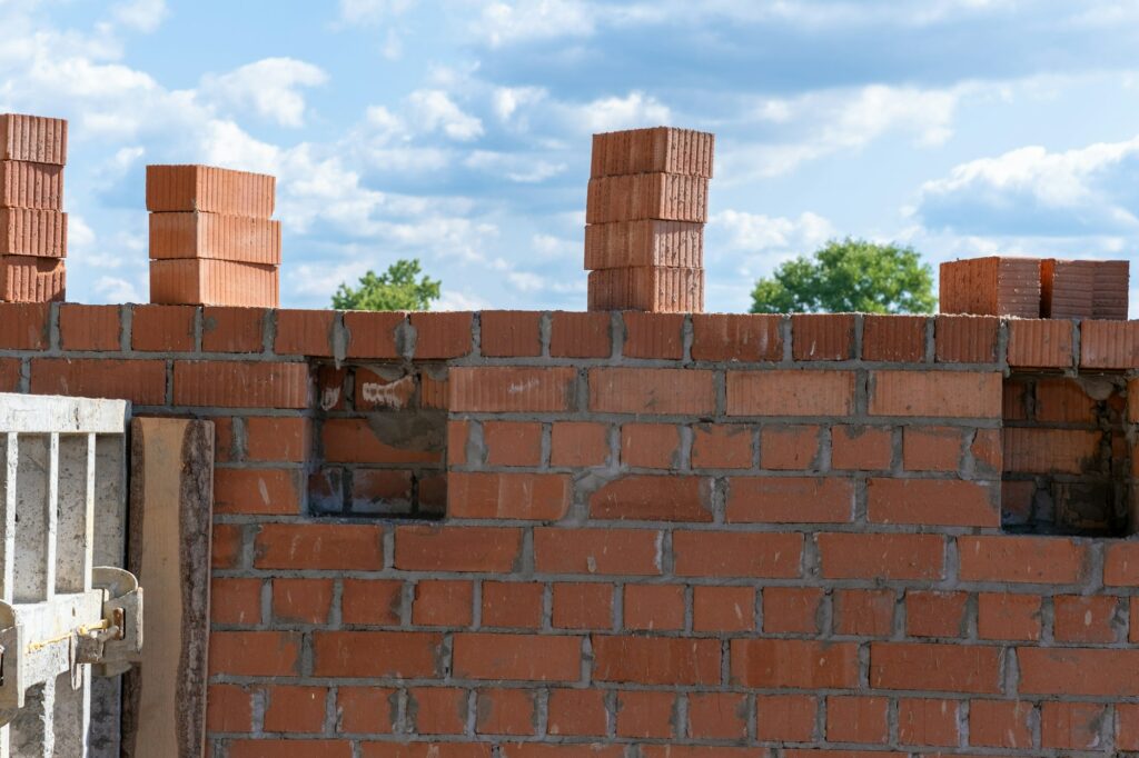 Unvollendete Ziegelwand des Massivhauses. Mauerwerk. Bau einer Backsteinmauer.